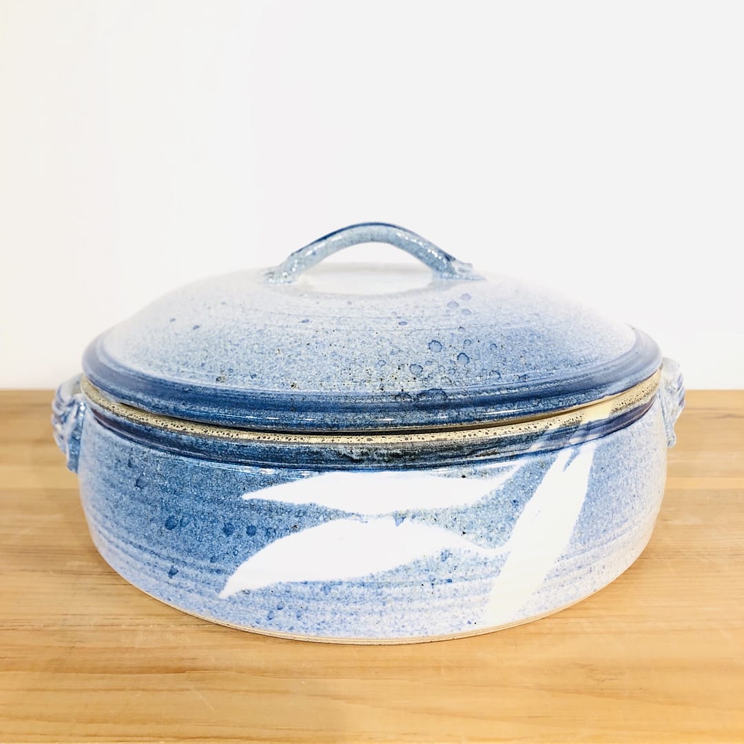 A casserole dish and lid glazed with white and blues