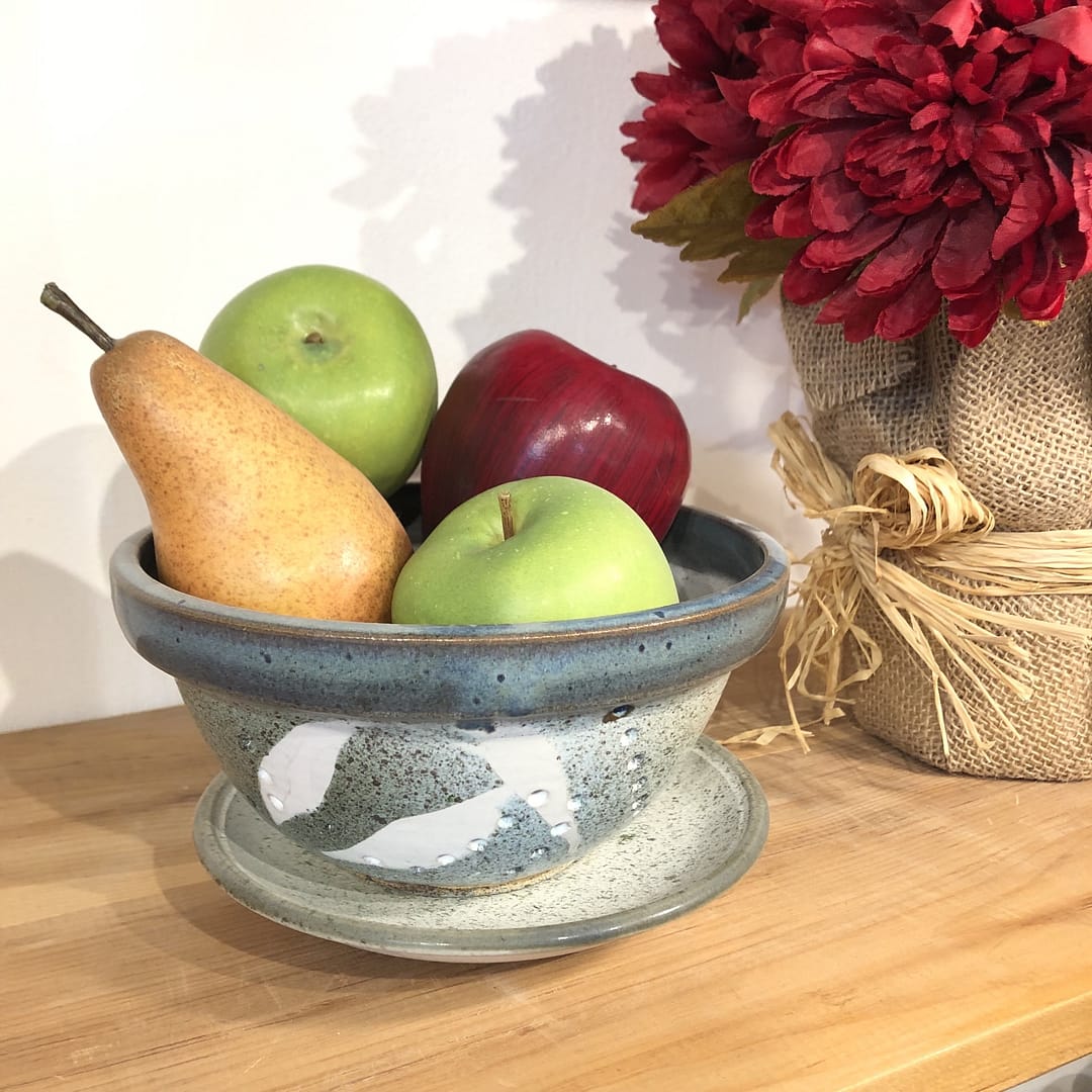 A small kitchen colander glazed in routil blue and turqoise