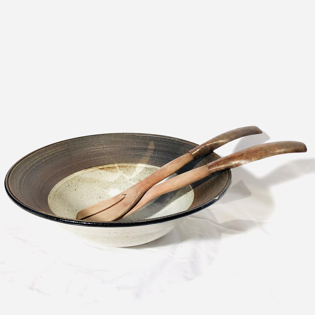 A large brown salad bowl with a wide rim