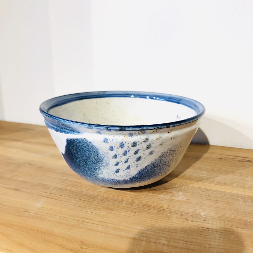 A small blue bowl with patterned blue and white glazes