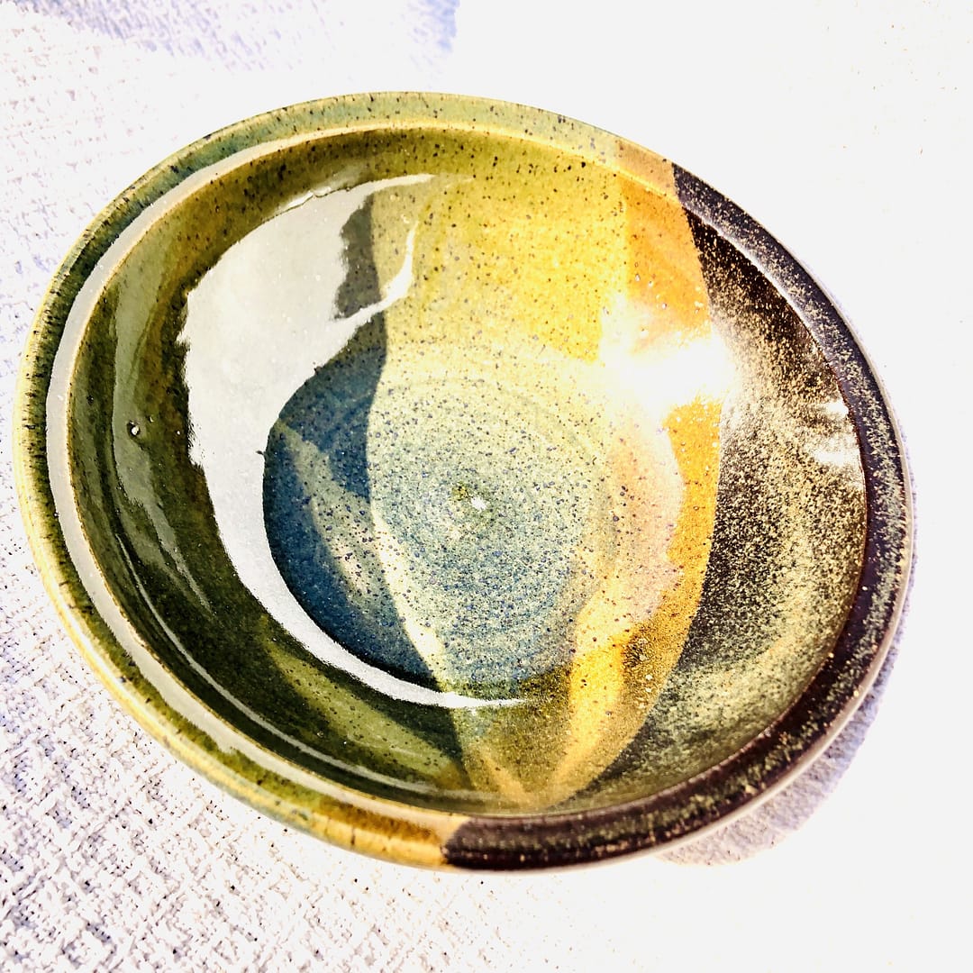A serving bowl with layers of green and temmoku brown glaze