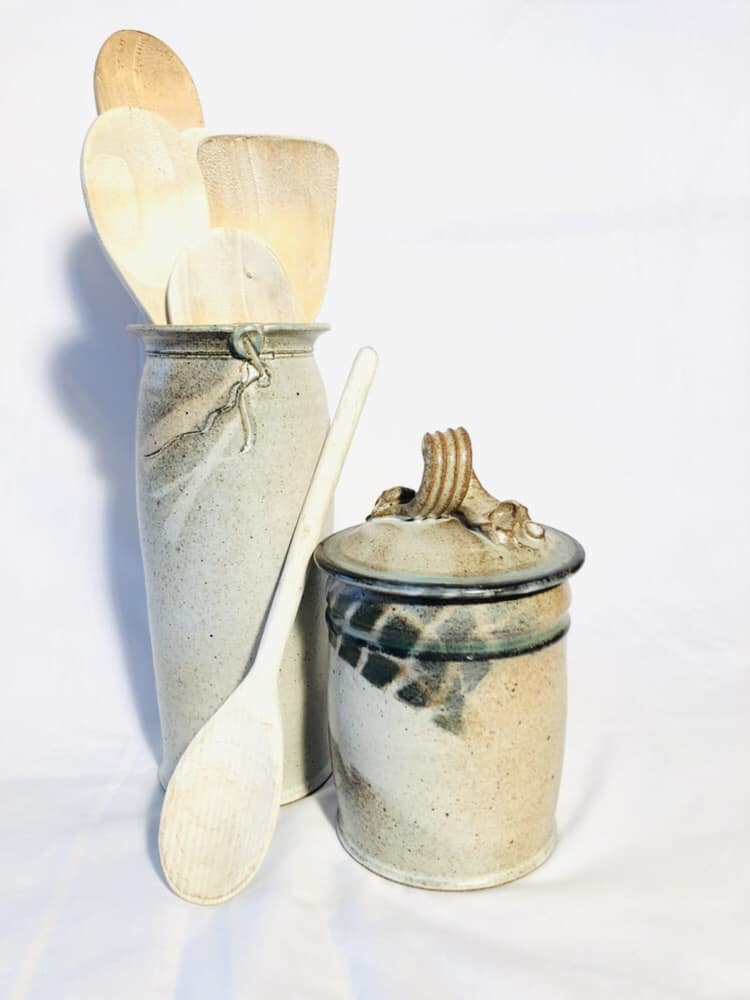 A tall vase used as a kitchen utensil holder and a dry good jar. They are glazed in turquoise