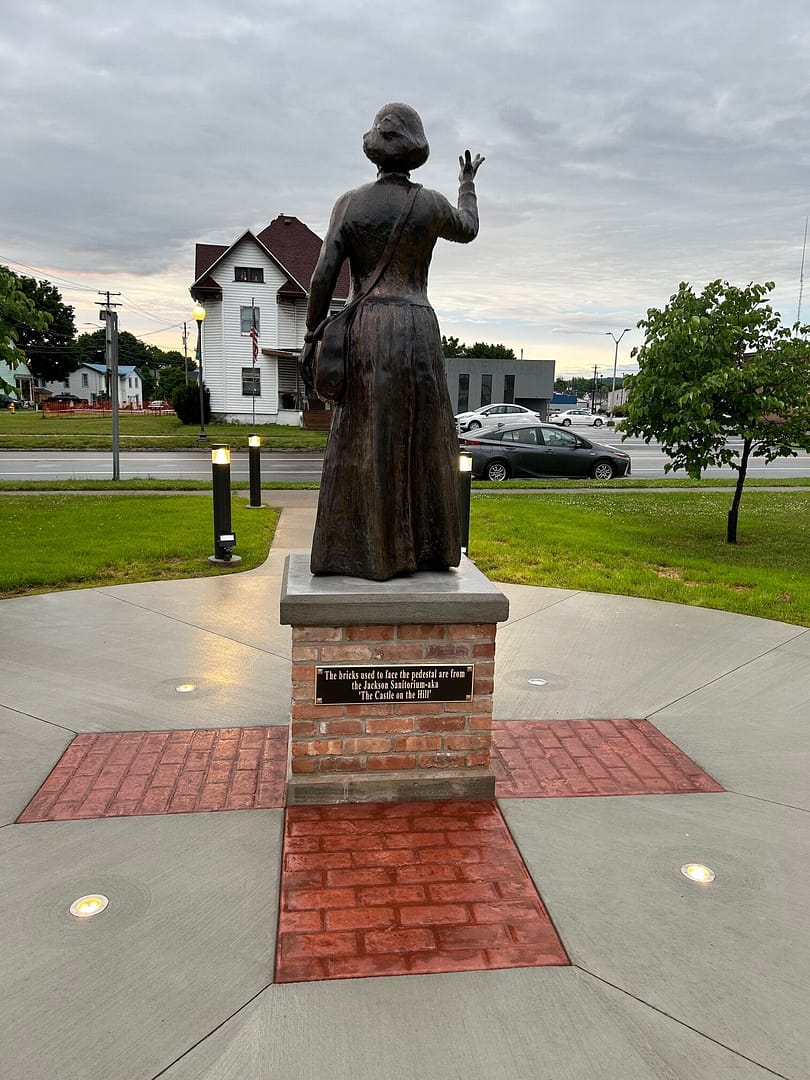 Rear view of the final installed Clara Barton Sculpture on an outdoor masonry pedestal