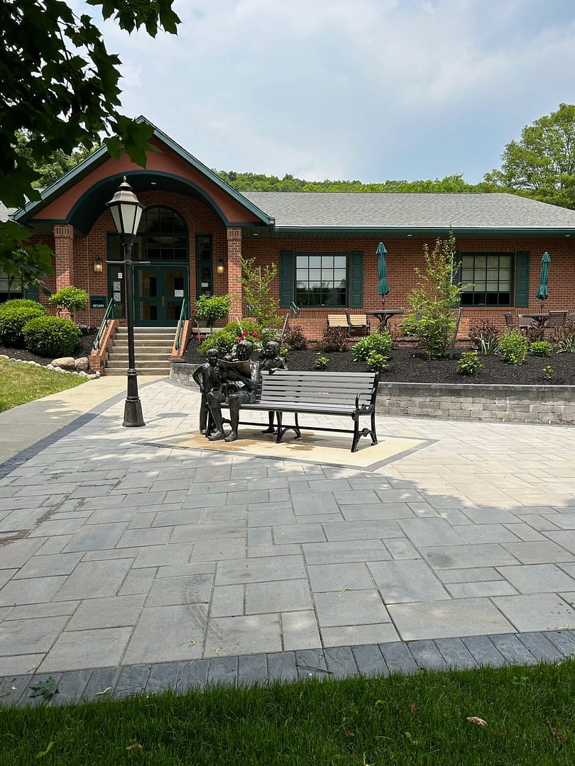 Final installation of the seated sculpture on a bench outside the library